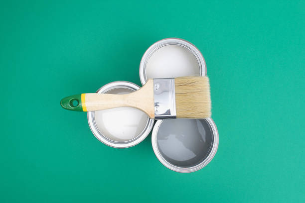 istock Open paint enamel cans on green turquoise palette samples. 1287116177