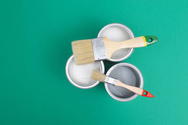 istock Open paint enamel cans on green turquoise palette samples. 1287116182