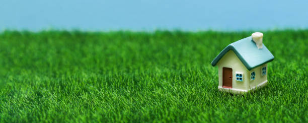istock Small toy house on a background of grass and sky. 1287116202