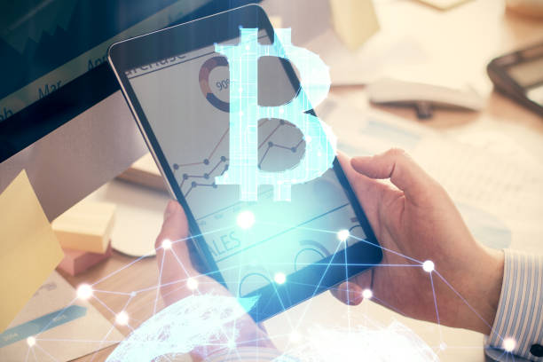 istock Double exposure of man's hands holding and using a phone and crypto currency blockchain theme drawing. 1287117542
