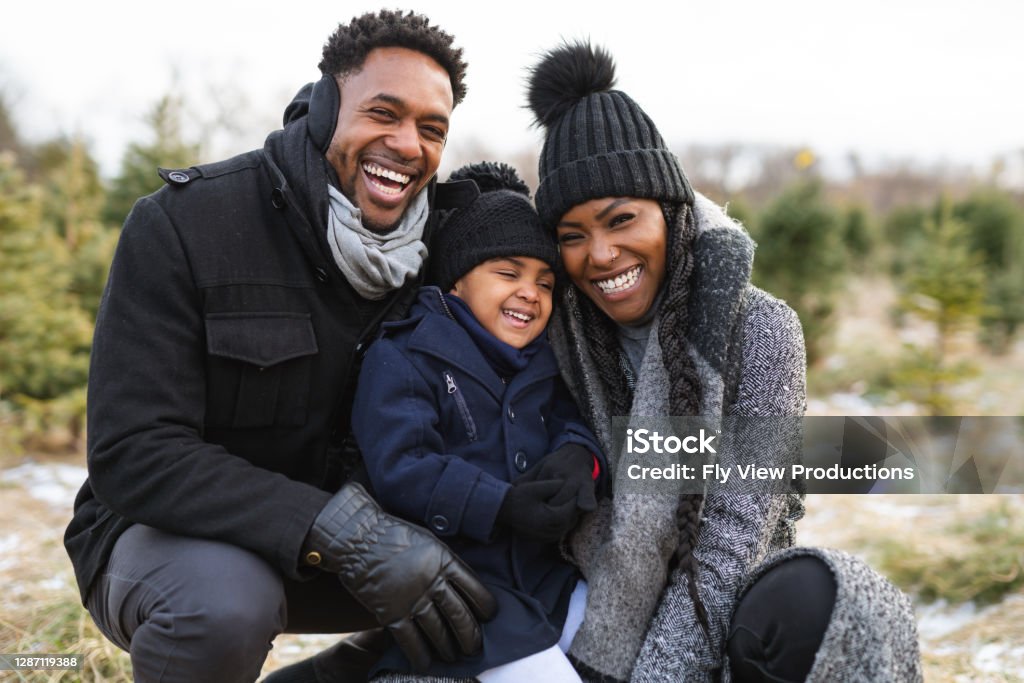 Ein Porträt einer jungen Familie auf einem Weihnachtsbaumhof - Lizenzfrei Familie Stock-Foto