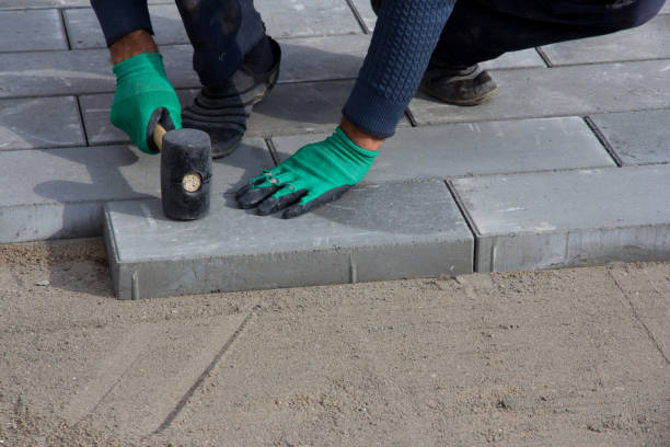 istock Brick Paver Working. Worker lay paving tiles, construction of brick pavement. Architecture background 1287119853