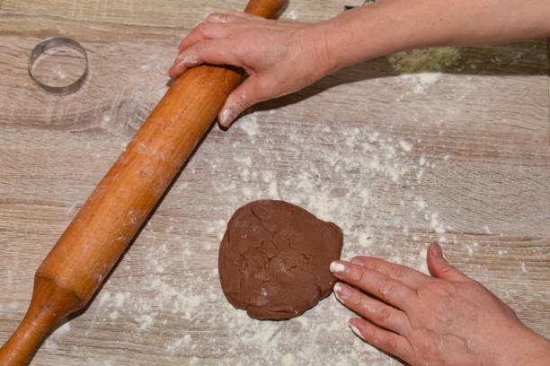 istock Hands knead the dough on a wooden table. Close-up. Technology for making dough. 1287119950