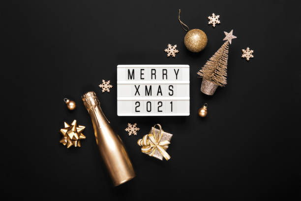 istock Lightbox with text MERRY XMAS 2021 and golden christmas decor on black background. Creative layout in monochrome colors 1287120616