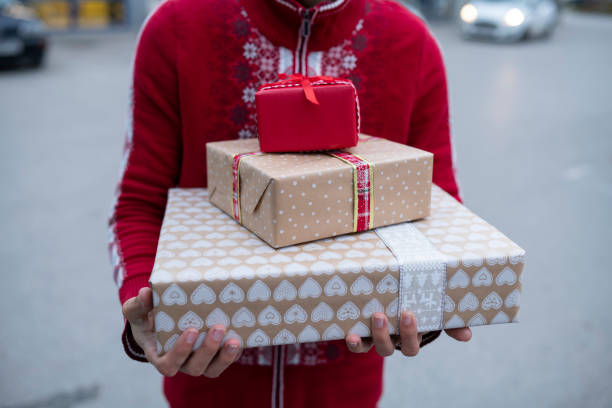 uomo con maglione natalizio che tiene una pila di regali di natale. - christmas stack gift carrying foto e immagini stock