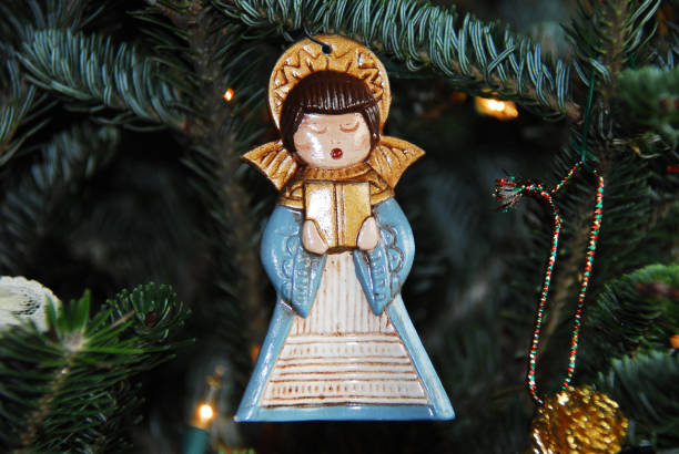 istock Christmas- A Handmade Ceramic Angel Ornament Hanging on a Tree 1287121086
