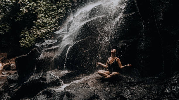 istock relaxed girl under a waterfall in Bali 1287123174