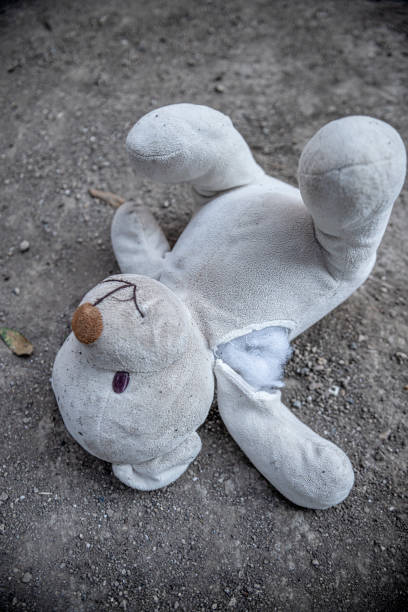 istock A damaged teddy bear on soil ground. 1287125891