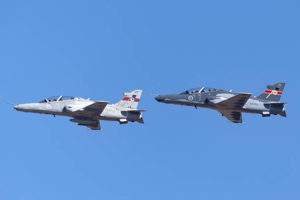 Two Royal Australian Air Force BAE Hawk 127 jet trainer aircraft taking off in formation from Avalon Airport. Avalon, Australia - March 4, 2013: Two Royal Australian Air Force (RAAF) BAE Hawk 127 lead in fighter trainer aircraft taking off in formation from Avalon Airport. british aerospace stock pictures, royalty-free photos & images