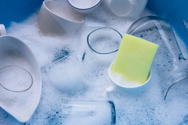 istock Washing used drinking glasses and cups with yellow sponge 1287128848
