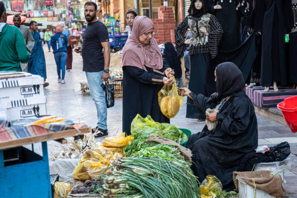 Mecca, Saudi Arabia - April 18, 2011: Arab street vendors with traditional clothings waiting for Muslim Pilgrims to sell headscarf, prayer beads in front of Mount Arafat aka Mount of Mercy which is the place Muslims believe the Islamic prophet Muhammad stood and delivered the Farewell Sermon to the Muslims in 632.