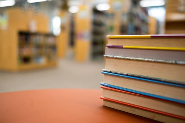 istock Stack of books on a wooden table in a library 1287131789