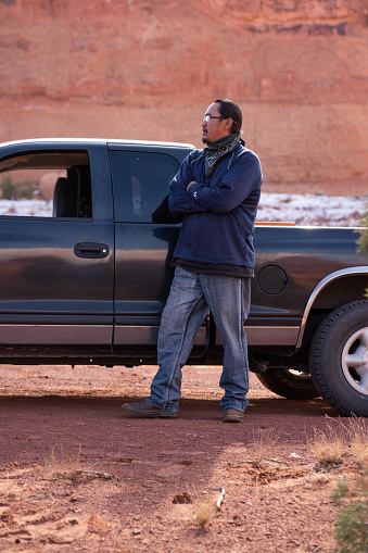 Confident Navajo man standing in front of a pick-up truck in Monument Valley