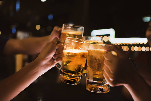 amigos asiáticos beber cerveza al aire libre en la cervecería para el festival de año nuevo por la noche - cerveza fotografías e imágenes de stock