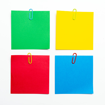 Set of four colors sticky note with paper clip isolated on white background