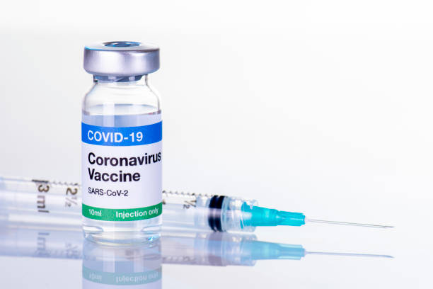 2019 Coronavirus vaccine bottle 10mL and syringe COVID-19 vaccine vial and hypodermic for immunization from SARS-CoV-19 macro simple layout with space for headline or text anti vaccination photos stock pictures, royalty-free photos & images