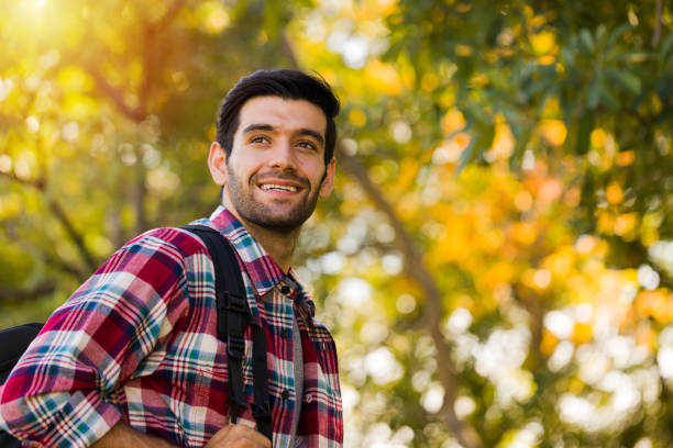 istock Handsome young traveler with trees and nature. 1287143415