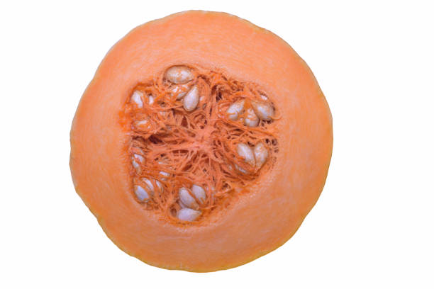 Fresh orange pumpkin cut in half with seeds, photographed against white clipping background