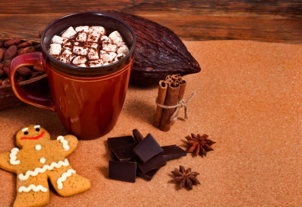 istock Cacao drink with marshmallows, gingerbread man, chocolate, spices, cocoa pod and beans 1287145770