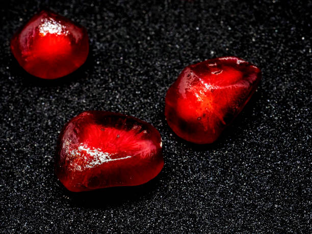 istock red grains of ripe pomegranate on a black background, macro 1287147734