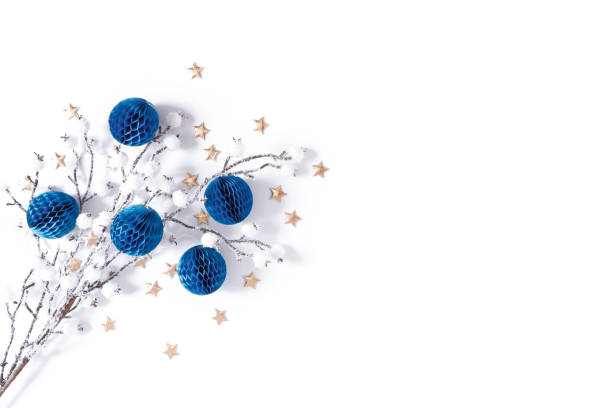 Modern winter layout made of a snow-covered branch, blue paper honeycomb balls and golden stars. Minimalistic template for christmas, new year, invitation, banner. Flat lay, top view, copy space. stock photo