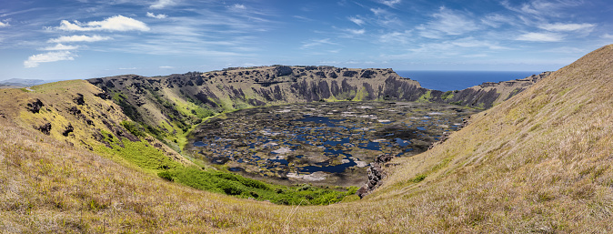 Rano Kau Volcano Crater Lake under blue summer sky. XXXL Stiched Panorama. Rano Kau is a extinct volcano that forms the southwestern headland of Easter Island, Isla de Pascua, Polynesia, Chile.