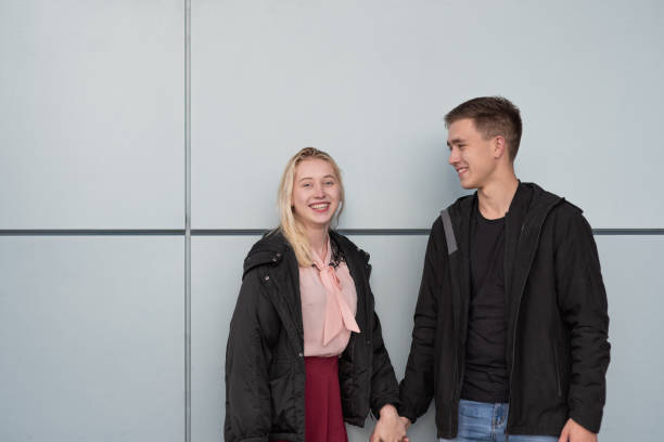 istock Happy young couple standing near gray wall 1287155271