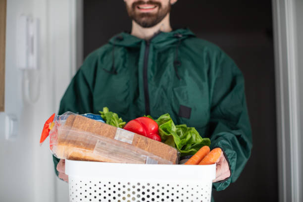 istock Delivery guy with plastic crate full of groceries 1287162294