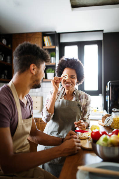 istock Beautiful young couple having fun and laughing while cooking in kitchen 1287163259