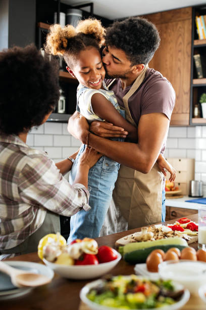 feliz familia preparando alimentos saludables en la cocina juntos - child eating healthy eating healthy lifestyle fotografías e imágenes de stock