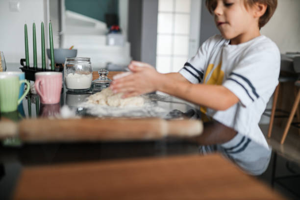 istock Kid in the kitchen, Cute son preparing the dough, bake cookies in the kitchen 1287163600