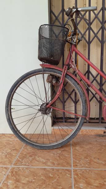 istock An old red bicycle parked next to the house. 1287164397