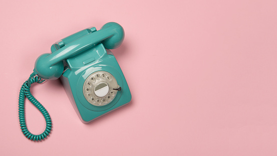 Teléfono vintage azul en un fondo rosa con espacio de copia photo