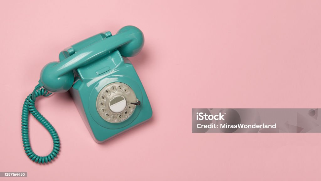 Blue vintage phone on a pink background with copy space Rotary Phone Stock Photo
