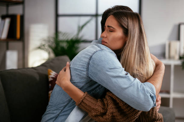 Girlfriend comforting her sad boyfriend. Young man having a problem. Girlfriend comforting her sad boyfriend. mercy hug stock pictures, royalty-free photos & images