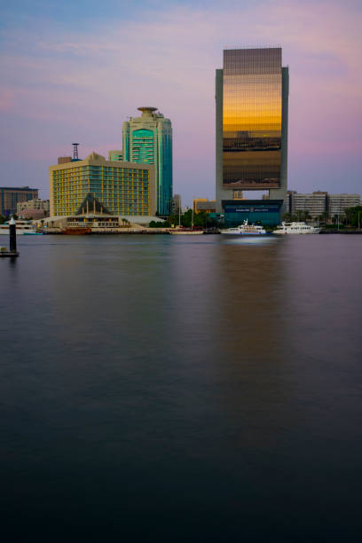 vista do riacho dubai em old dubai na área de al seef. arranha-céus e barcos à vista do pôr do sol. - dubai skyscraper architecture united arab emirates - fotografias e filmes do acervo