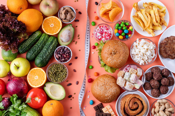 istock Fruit and vegetables vs sweets and fast food top view flat lay on orange background 1287169806