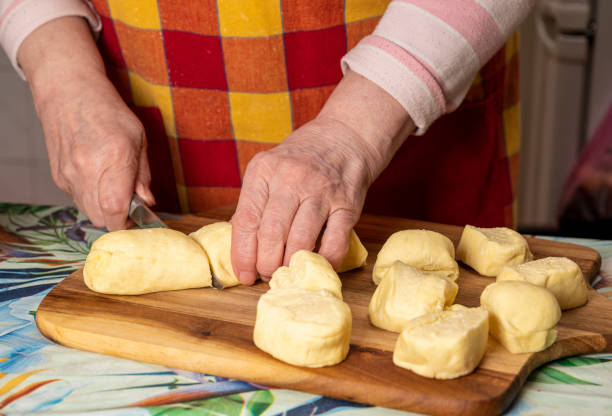 istock Woman cutting dough with a knife on the kitchen table 1287171569