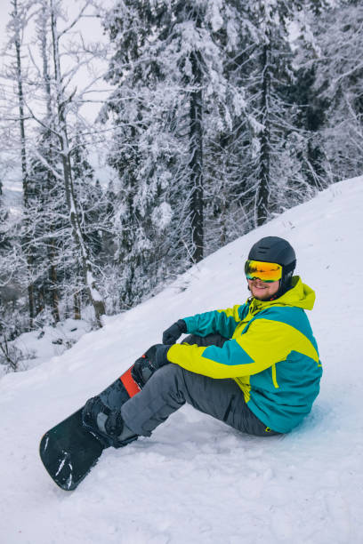 istock man strap in snowboard. winter sport activities 1287172526
