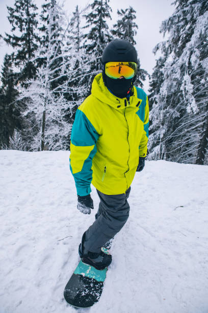 man riding snowboard by snowed hill man riding snowboard by snowed hill winter sport activities bukovel ski resort ukraine stock pictures, royalty-free photos & images
