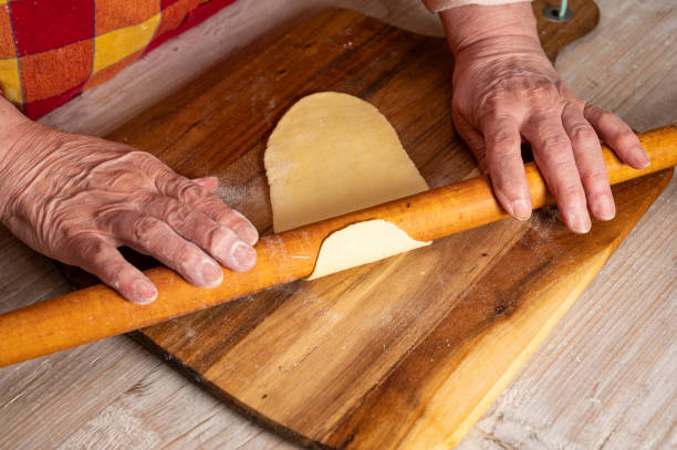 istock Woman rolling out the dough with a rolling pin on the kitchen table 1287173479