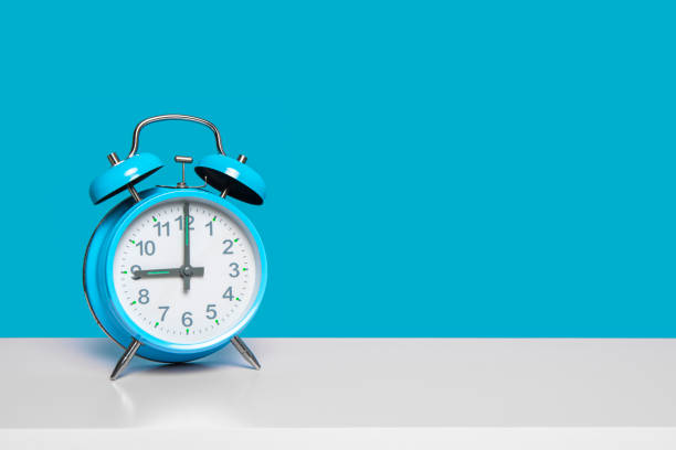 istock Blue vintage alarm clock at nine o clock on a blue background with space for copy 1287174461