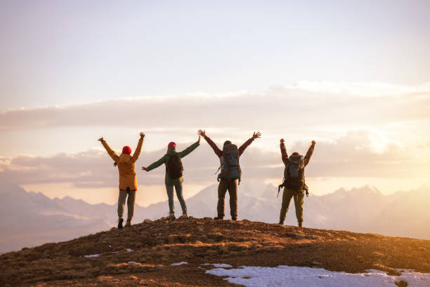 istock Four tourists stands at mountain top at sunset 1287175210