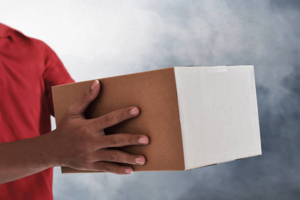 istock Delivery man holding cardboard box 1287175977