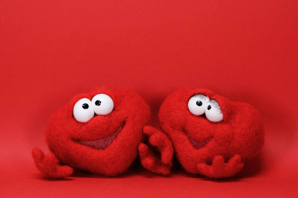 Two toy red hearts on red background with copy space for text, symbol of love, healtcare, valentines day concept