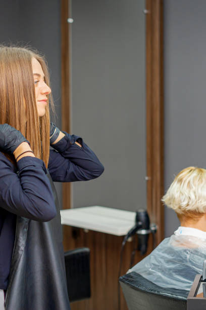 istock Hairdresser puts on black apron 1287179467