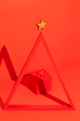 Conceptual Christmas tree with red gift box on red background