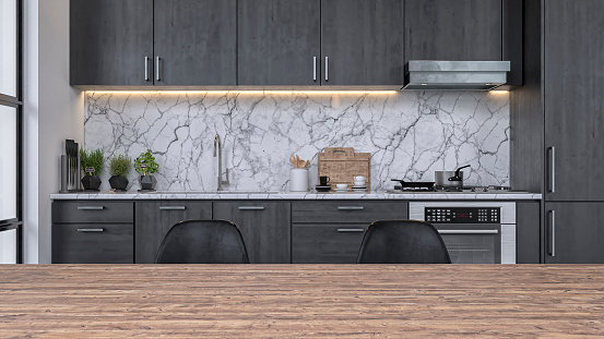 Empty modern kitchen with dark gray wooden kitchen cabinets, white and gray marble background and large hardwood dining table with copy space in the foreground. A window on a side and with focus on background. 3D rendered image.