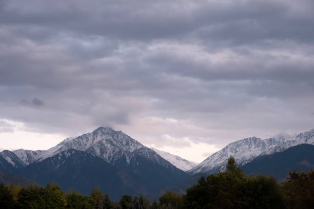 istock Mountains cowered with snow and cloudy sky background. Bad weather concept. 1287181173