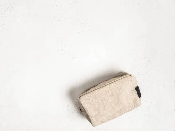 Eco textile cosmetic bag on grey background. top view. Copy space